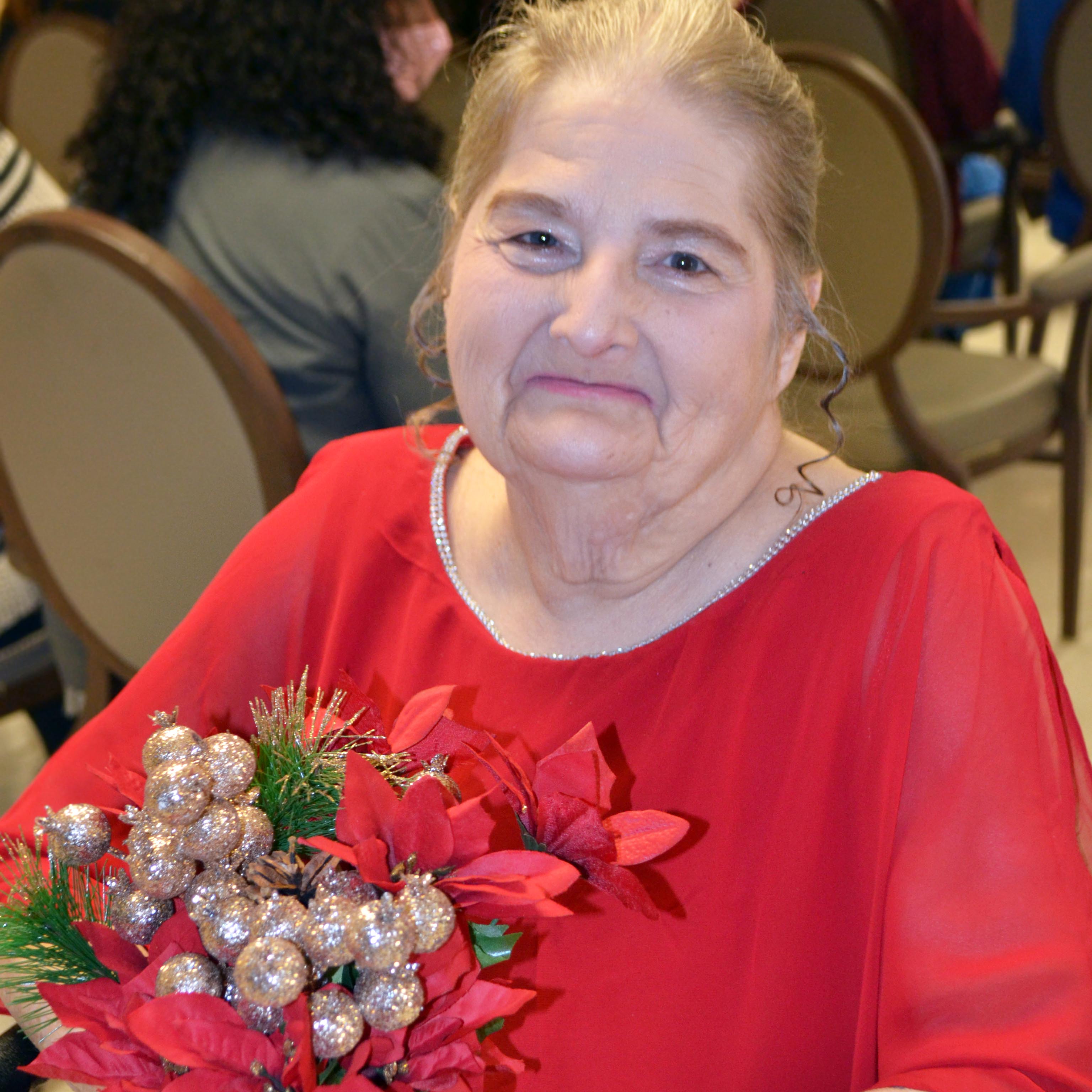 Photo of Doreen smiling while holding wedding flowers